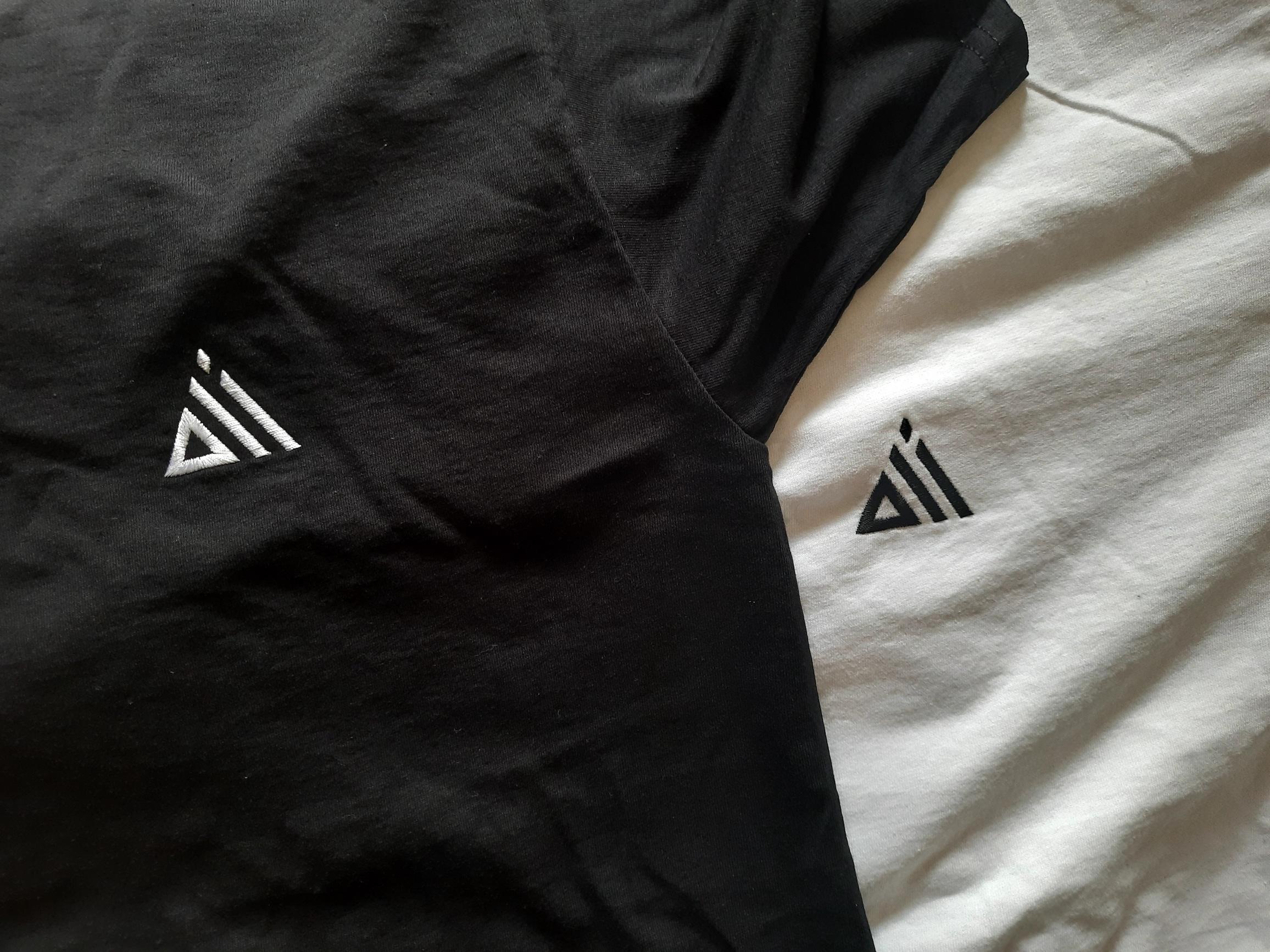 Black and white t-shirts embroidered with the Oli logo